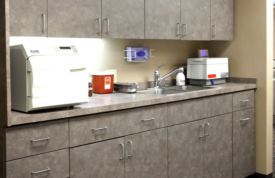 The sterilisation area, with an autoclave, gloves and a sink along one counter.