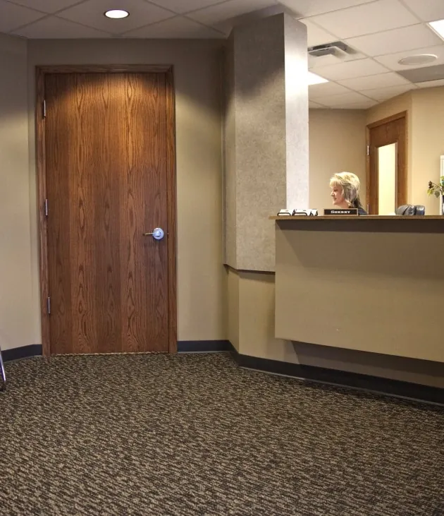 The reception desk beside the waiting room, with a receptionist at work.